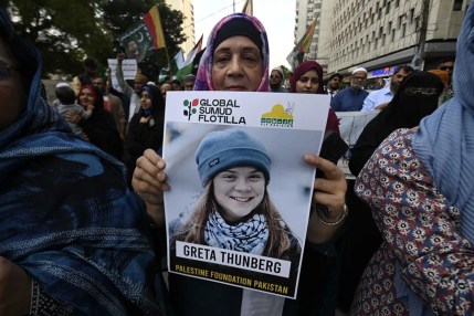 Personas portan una foto de la activista climática sueca y activista de la Flotilla Global Sumud (GSF), Greta Thunberg, mientras participan en una protesta