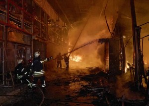 Rescatistas ucranianos trabajan para extinguir un incendio en el lugar de un ataque ruso contra un mercado en Járkov