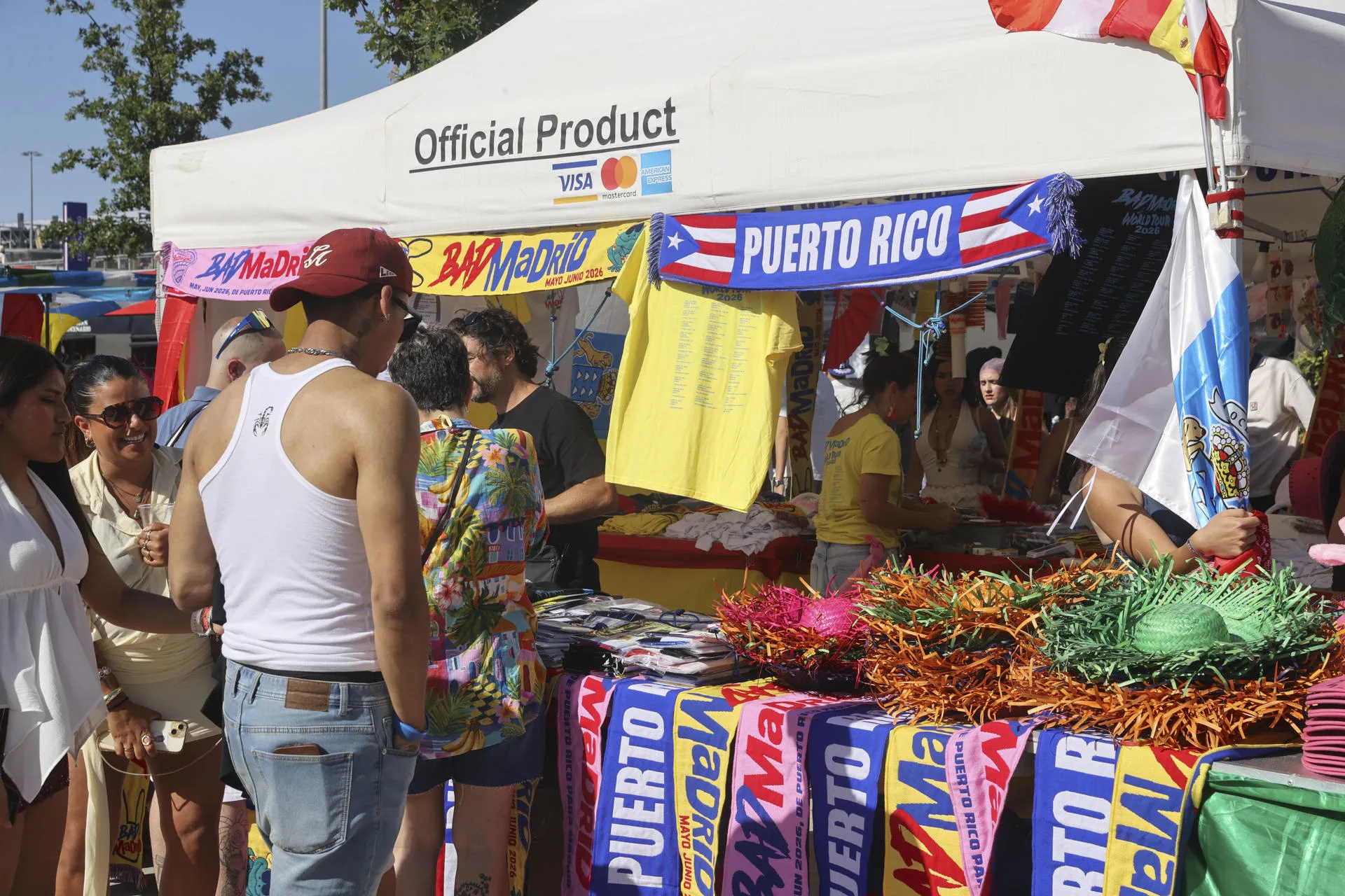 Varias personas visitan un puesto de mercadotecnia en las inmediaciones del estadio Metropolitano, momentos antes del concierto del artista puertorriqueño Bad Bunny, este miércoles en Madrid. EFE/ Victor Lerena