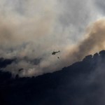 Una treintena de medios de extinción mantiene este domingo las labores para tratar de consolidar el perímetro de un incendio forestal declarado el sábado en el término municipal de Navas de San Antonio, en Segovia, por un vehículo que comenzó a arder en el arcén de la autopista AP-6. EFE/Pablo Martín